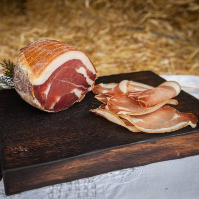 une planche avec un morceau de jambon sec de porc